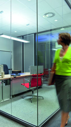 Woman is looking to the Philips light illuminating the private office of Audi