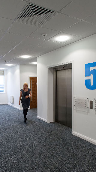 The corridor of Manchester Airport Olympic House illuminated by Philips led office lighting.