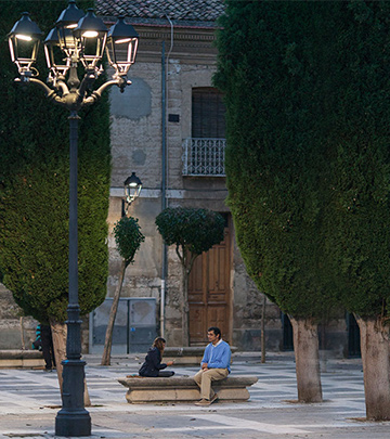 Man and child playing cards on street of Palencia lit by Philips lighting